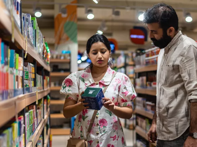 Woman and man reading food label on a box of sweets