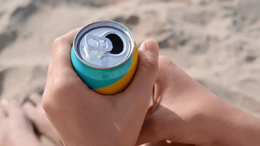 Holding can on beach